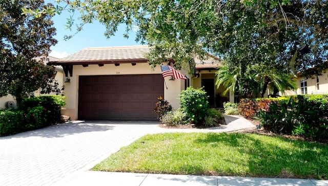 view of front facade featuring decorative driveway, a garage, and stucco siding