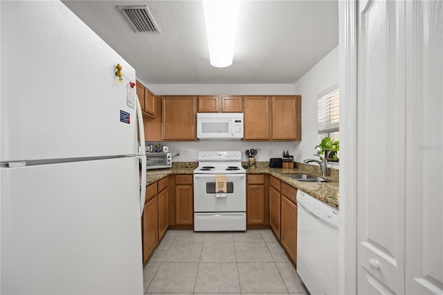 10959 Keys Gate Dr, Riverview, FL 33579 - kitchen featuring a sink, brown cabinetry, visible vents, light stone counters, and white appliances