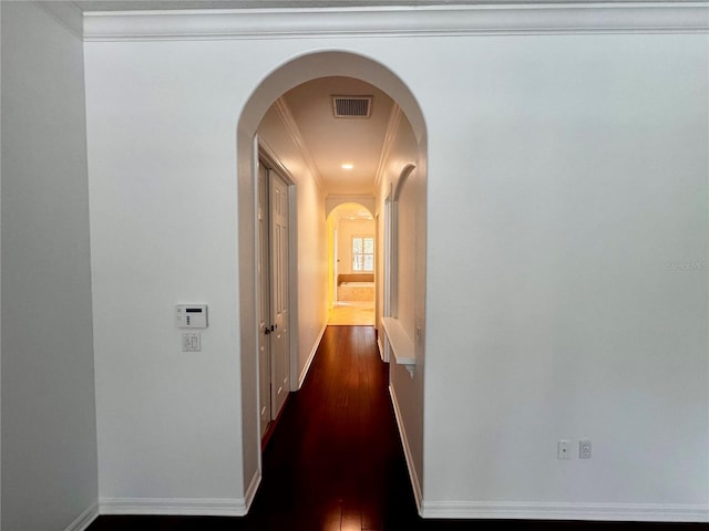 hall featuring dark wood-type flooring and ornamental molding