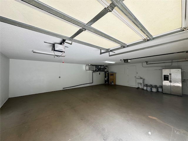 garage with a garage door opener, stainless steel fridge, and electric water heater