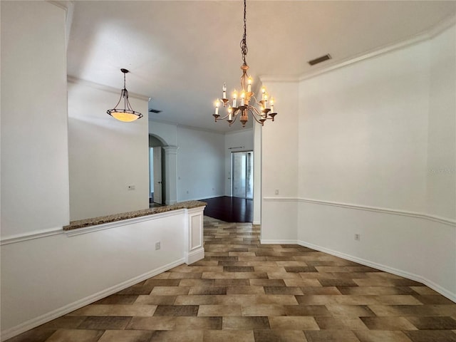 interior space with baseboards, visible vents, arched walkways, ornamental molding, and an inviting chandelier