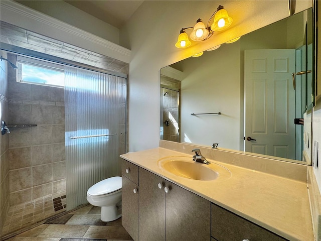 bathroom featuring toilet, vanity, tiled shower, and tile patterned floors