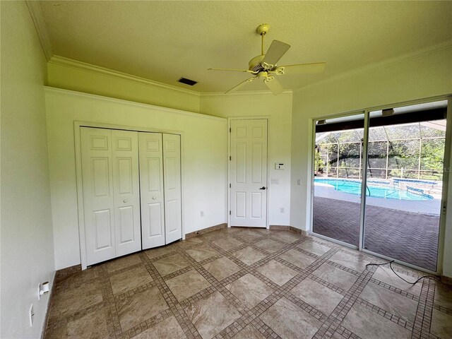 unfurnished bedroom with ceiling fan, crown molding, a closet, and access to exterior