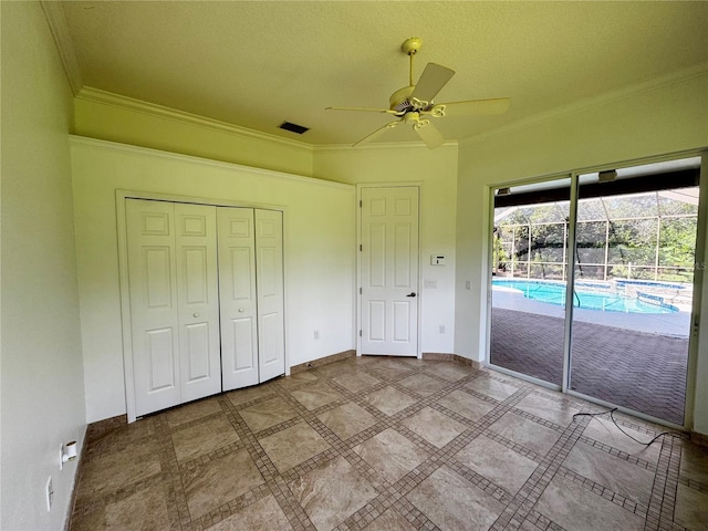 unfurnished bedroom featuring baseboards, ceiling fan, ornamental molding, access to exterior, and a closet