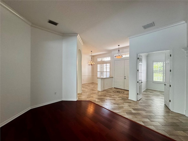 interior space with a healthy amount of sunlight, light wood finished floors, and crown molding