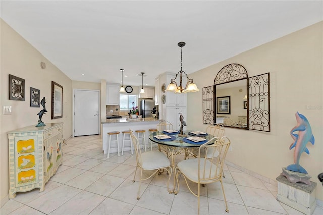 dining space with light tile patterned floors, baseboards, and an inviting chandelier