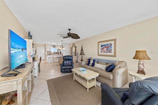 living area featuring ceiling fan with notable chandelier and light tile patterned floors