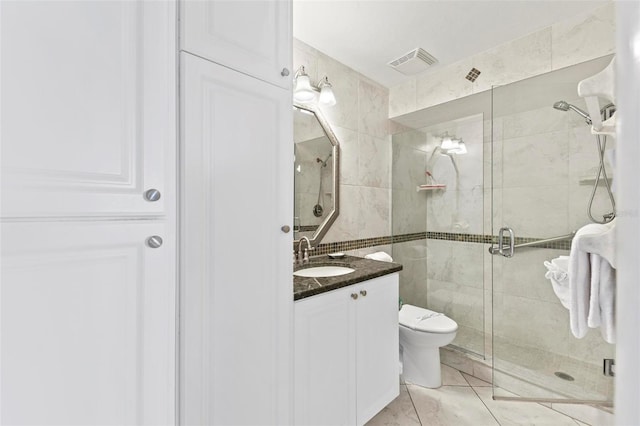 full bathroom featuring toilet, a shower stall, visible vents, and vanity