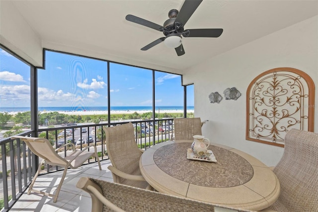 sunroom / solarium with a water view and ceiling fan