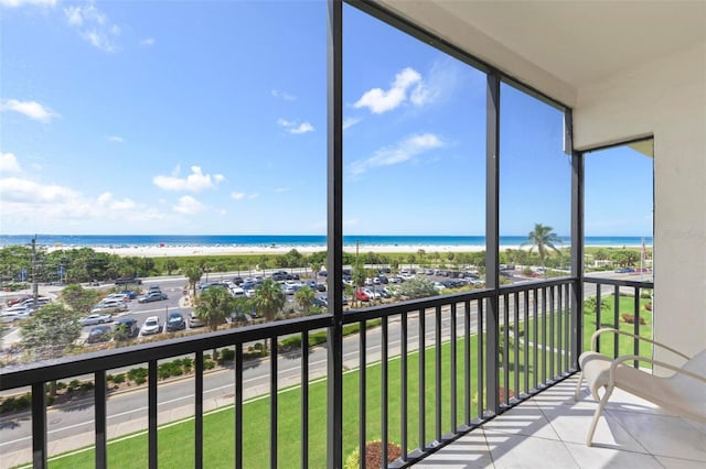 balcony featuring a view of the beach and a water view