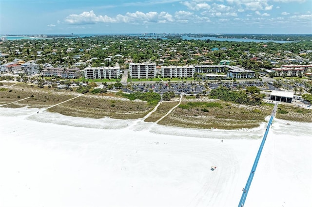 bird's eye view with a water view, a view of the beach, and a city view