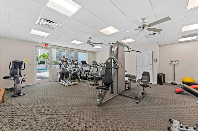 workout area featuring ceiling fan, visible vents, a drop ceiling, and carpet flooring