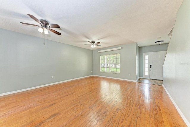 empty room featuring a textured ceiling, ceiling fan, and light hardwood / wood-style floors