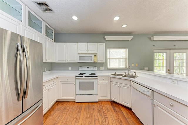 kitchen featuring white appliances, white cabinetry, and sink