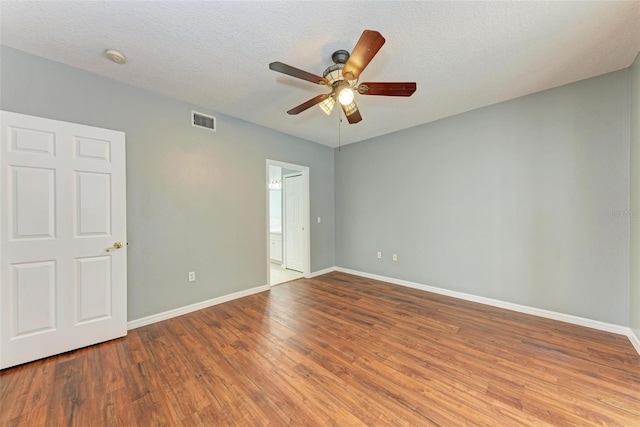 empty room featuring a textured ceiling, hardwood / wood-style flooring, and ceiling fan