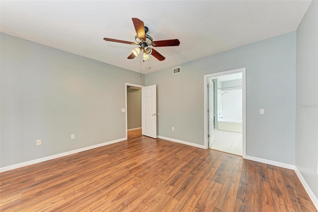 unfurnished bedroom with a textured ceiling, ceiling fan, and hardwood / wood-style floors