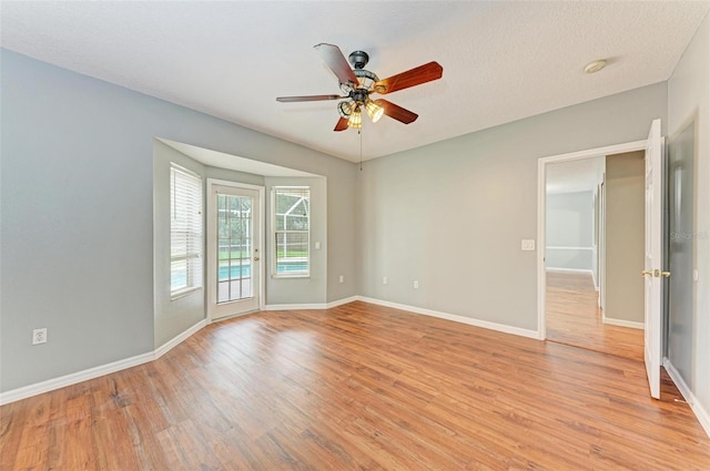 unfurnished room featuring light wood-type flooring, ceiling fan, and a textured ceiling