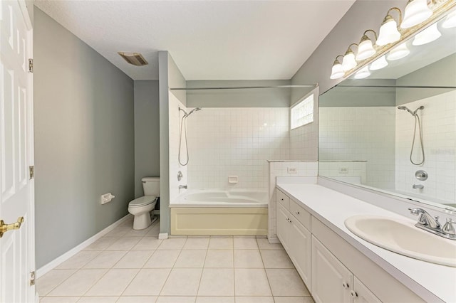 full bathroom with tile patterned flooring, toilet, tiled shower / bath combo, vanity, and a textured ceiling