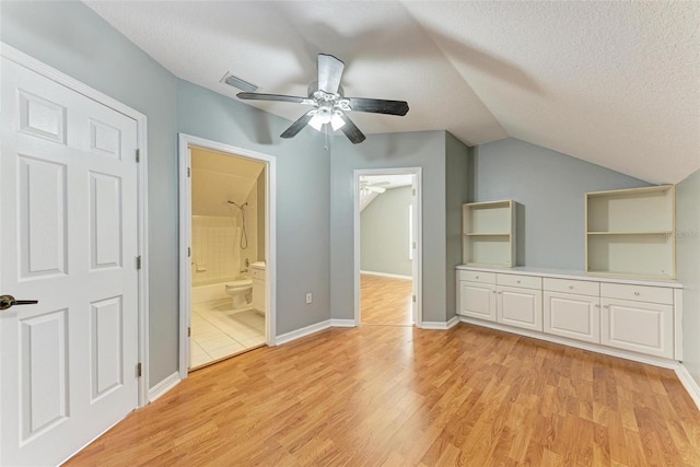 bonus room featuring light wood-type flooring, vaulted ceiling, a textured ceiling, and ceiling fan