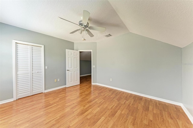 unfurnished bedroom featuring light wood-type flooring, a closet, ceiling fan, and vaulted ceiling