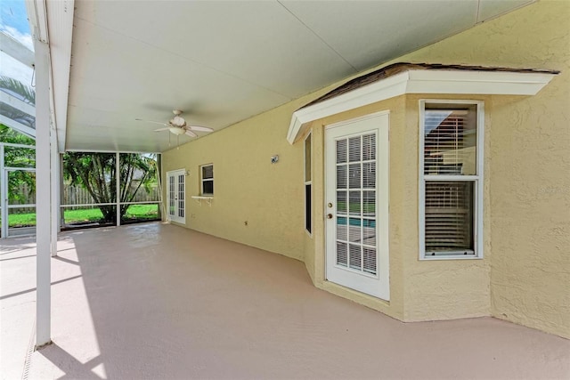 view of patio with glass enclosure and ceiling fan