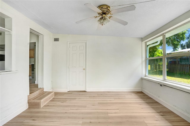 spare room featuring a textured ceiling, ceiling fan, and light hardwood / wood-style floors