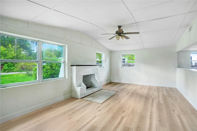 unfurnished living room featuring a wealth of natural light, light hardwood / wood-style floors, a high end fireplace, and ceiling fan