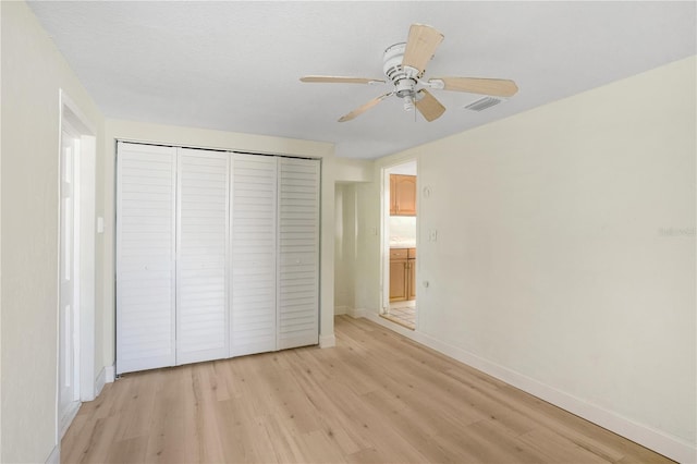 unfurnished bedroom with light wood-type flooring, a closet, and ceiling fan