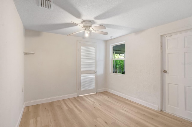 empty room featuring a textured ceiling, ceiling fan, and light hardwood / wood-style floors