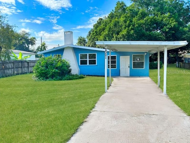 view of front of house with a carport and a front lawn