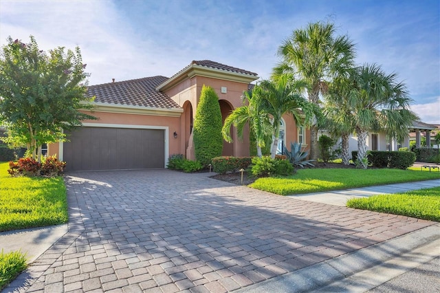 mediterranean / spanish house featuring a front yard and a garage