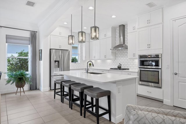 kitchen featuring backsplash, double wall oven, fridge, range hood, and sink