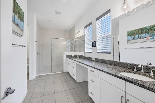 bathroom with a shower with door, toilet, tile patterned floors, and vanity