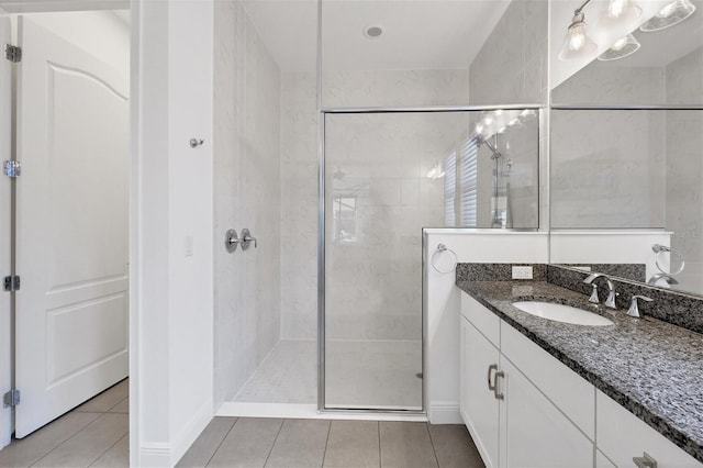 bathroom with tiled shower, tile patterned flooring, and vanity