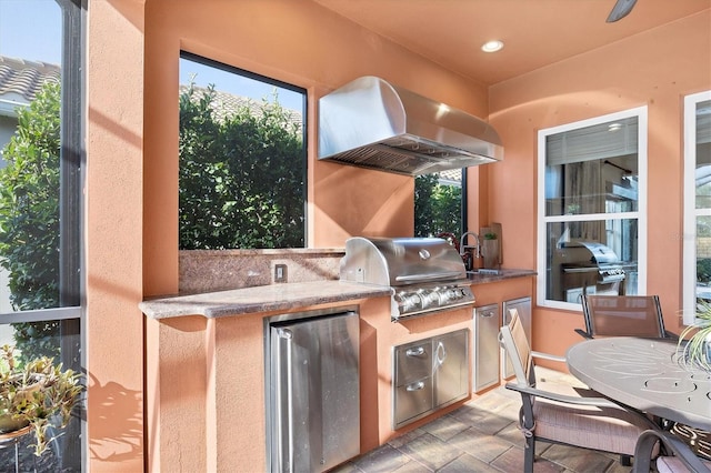 view of patio / terrace with exterior kitchen, sink, and a grill