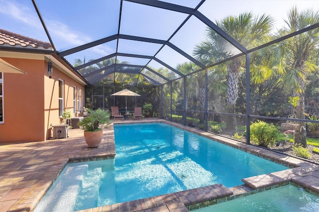 view of swimming pool with glass enclosure and a patio