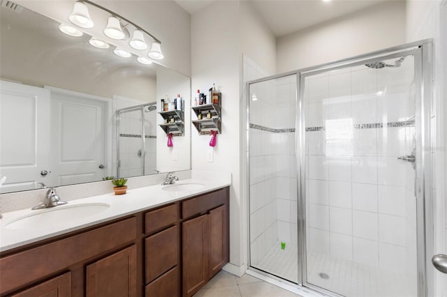 bathroom with tile patterned flooring, vanity, and walk in shower