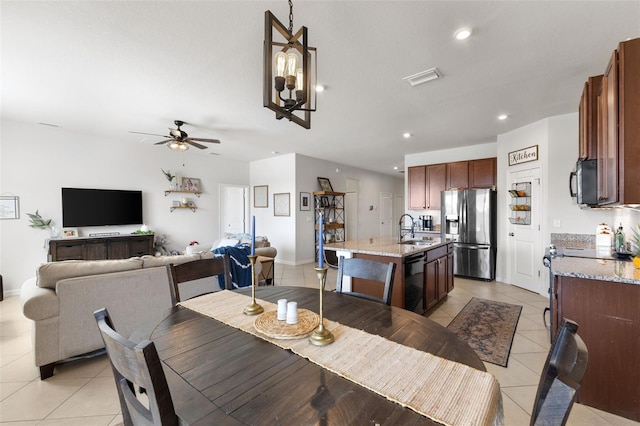 dining room with light tile patterned floors, sink, and ceiling fan with notable chandelier