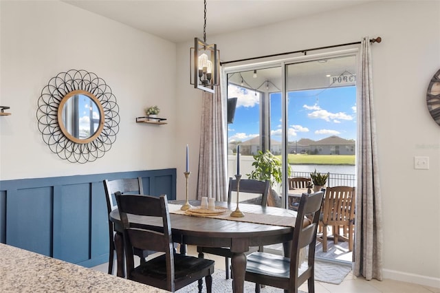 dining space with a healthy amount of sunlight, light tile patterned flooring, and a water view