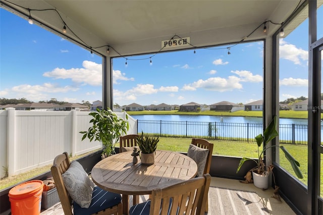 sunroom / solarium featuring a water view