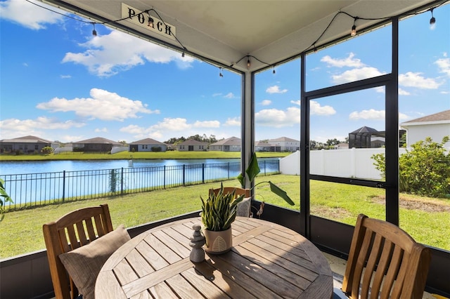 sunroom featuring a water view