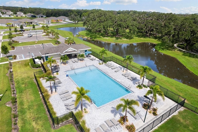 view of swimming pool featuring a patio area, a lawn, and a water view