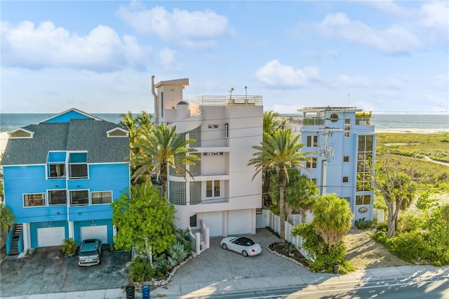 view of building exterior with a water view, driveway, and an attached garage