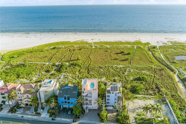 birds eye view of property with a water view and a beach view