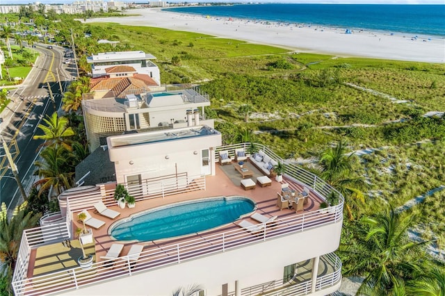 birds eye view of property with a water view and a beach view