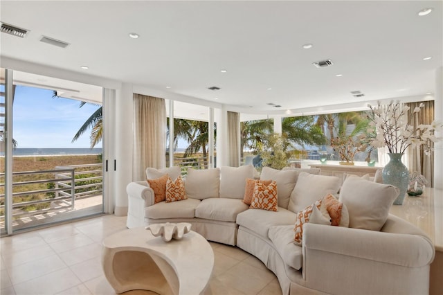 living room with plenty of natural light, visible vents, and floor to ceiling windows