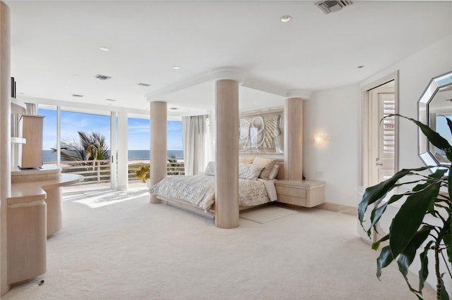 bedroom with access to exterior, light colored carpet, floor to ceiling windows, and visible vents