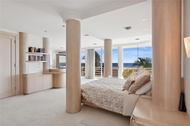 bedroom with access to exterior, visible vents, ornate columns, and light colored carpet