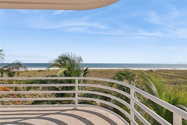 balcony featuring a water view and a beach view