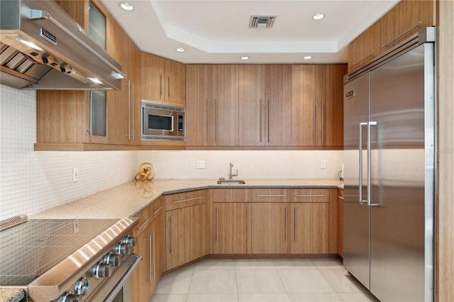 648 Beach Rd, Sarasota, FL 34242 - kitchen with built in appliances, range hood, a sink, light stone counters, and tasteful backsplash